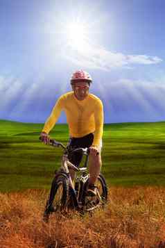 年轻的男人。穿黄色的自行车衬衫骑山自行车mtb