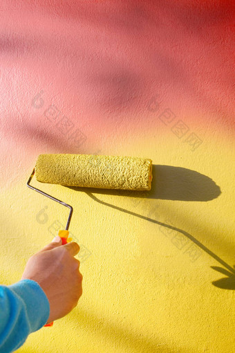 手绘画黄色的墙辊画家刷