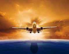 乘客飞机飞机飞行美丽的海水平太阳集