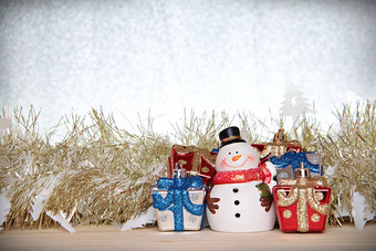 可爱的雪人圣诞节礼物盒子礼物黄金彩带俗丽的木银闪闪发光的背景