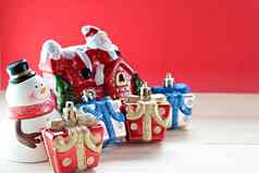可爱的雪人圣诞节礼物盒子礼物圣诞老人老人房子木红色的背景