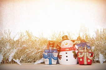 可爱的雪人圣诞节礼物盒子礼物黄<strong>金彩带</strong>俗丽的木银闪闪发光的背景