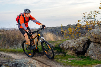 骑自行车的人红色的夹克骑自行车岩石小道极端的体育运动
