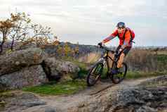 骑自行车的人红色的夹克骑自行车岩石小道极端的体育运动