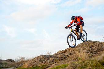 骑自行车的人红色的夹克骑自行车岩石山极端的体育运动
