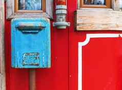 蓝色的邮箱挂红色的墙