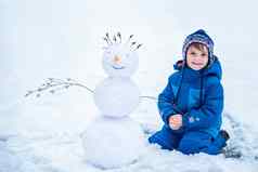 男孩坐着微笑雪人