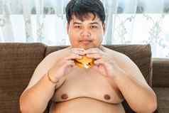 脂肪男人。吃汉堡坐着