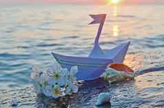 纸船贝壳用钉子钉上樱桃花朵海滨