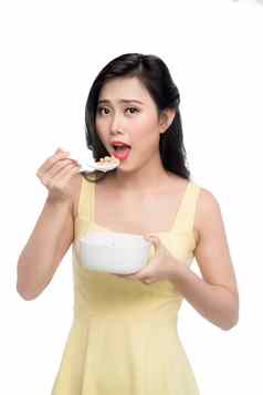 亚洲女人吃碗麦片牛奶什锦早餐早餐