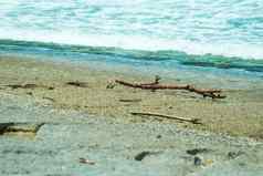 海水波沙子石头海泡沫棒卡住了海滩