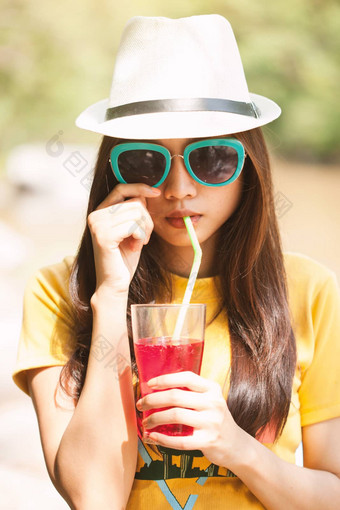 女人喝冰饮料在户外沙子海