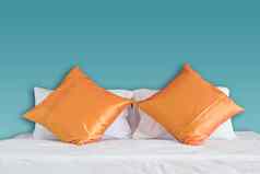 蓝色的墙橙色枕头白色床上