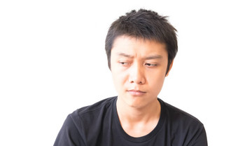 亚洲年轻的男人。抑郁症脸特征