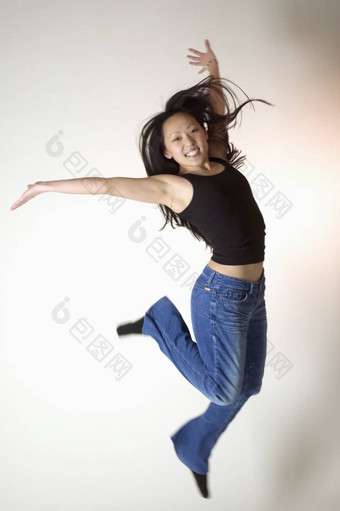年轻的亚洲女人跳跃快乐
