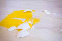 破碎的蛋下降了地板上摊黄色的蛋黄