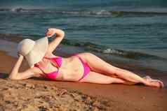 女人大稻草遮阳帽日光浴桑迪海滩夏天