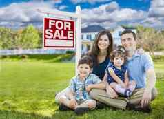 年轻的家庭孩子们前面自定义首页出售真正的房地产标志