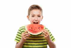 英俊的微笑孩子男孩持有红色的西瓜水果片