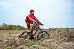 快乐骑自行车的人红色的休息自行车岩石小道冒险体育运动旅行骑自行车概念