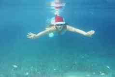 女人圣诞老人他游泳水下
