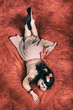 美女照片女孩摆姿势红色的床上