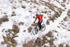 骑自行车的人红色的骑山自行车雪小道极端的冬天体育运动复古骑自行车概念