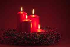 红色的燃烧出现圣诞节蜡烛浆果花环红色的背景