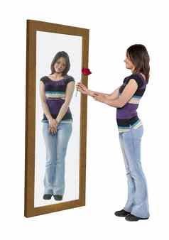 年轻的女人给花反射镜子