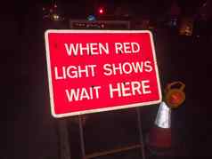 红色的建设标志晚上路红色的光显示等待