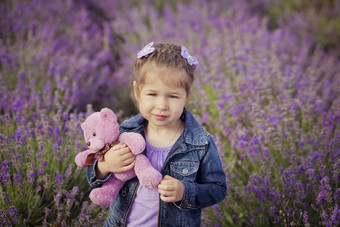 漂亮的年轻的女孩坐着薰衣草场不错的他乘船的人紫色的花