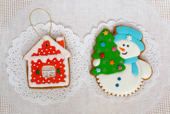 姜饼饼干形状圣诞节树雪人小房子白色餐巾背景前视图平躺复制空间