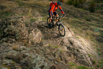 骑自行车的人红色的骑自行车秋天岩石小道极端的体育运动复古骑自行车概念