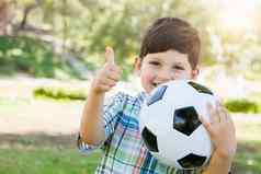 可爱的年轻的男孩玩足球球拇指在户外公园