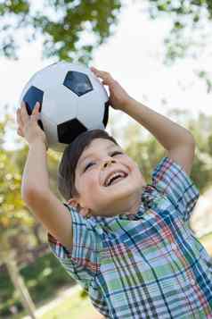可爱的年轻的男孩玩足球球在户外公园