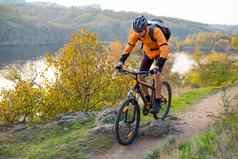骑自行车的人橙色骑山自行车秋天岩石小道极端的体育运动复古骑自行车概念