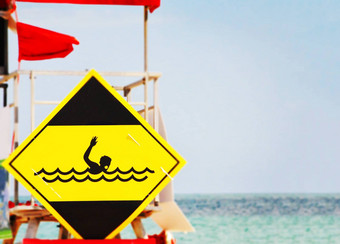 黄色的危险信号描绘溺水游泳运动员