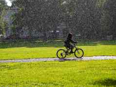 女孩自行车城市公园雨阳光
