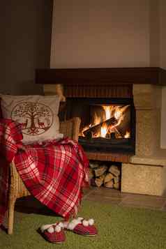 羊毛温暖的毯子格子红色的拖鞋pompons背景燃烧壁炉