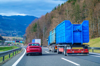 红色的车<strong>超车</strong>蓝色的卡车高速公路