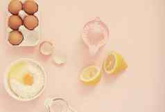 成分厨房烤工具烹饪柠檬蛋糕糖果鸡蛋面粉手榨汁机柔和的头昏眼花的粉红色的背景前视图假期烘焙生活
