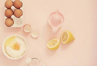 成分厨房烤工具烹饪柠檬蛋糕糖果鸡蛋面粉手榨汁机柔和的头昏眼花的粉红色的背景前视图假期烘焙生活