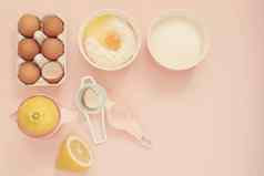 成分厨房烤工具烹饪柠檬蛋糕糖果鸡蛋面粉糖手榨汁机柔和的头昏眼花的粉红色的背景前视图假期烘焙生活