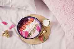 奶昔碗新鲜的浆果种子水果健康的早餐床上