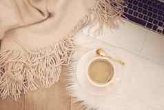舒适的冬天早晨咖啡移动PC温暖的围巾白色皮毛地毯地板上