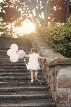 婴儿女孩楼梯持有气球古董太阳太阳阴霾眩光