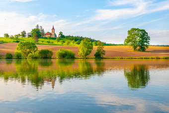 浪漫的景观小教堂山反映了池塘阳光明媚的夏天一天蓝色的天空白色云彼得保罗斯教堂拜西基拉兹涅贝洛赫拉德捷克共和国