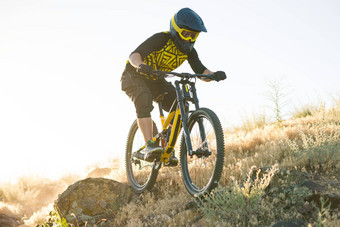 骑自行车的人骑山自行车夏天岩石小道晚上极端的体育运动复古骑自行车概念
