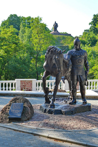 雕像骑士头盔持有马背景绿色树坡纪念碑战士前剑降低了