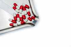 前视图红色的白色抗生素胶囊药片不锈钢钢药物托盘药物电阻抗生素药物合理的健康政策健康保险概念制药行业药店背景